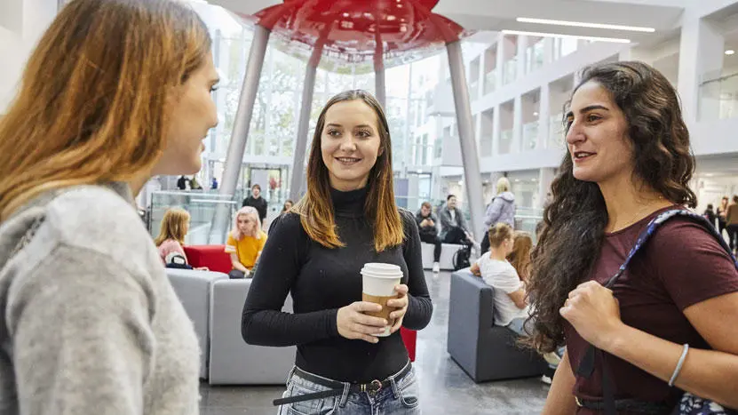 3 students chatting in the spark building. 